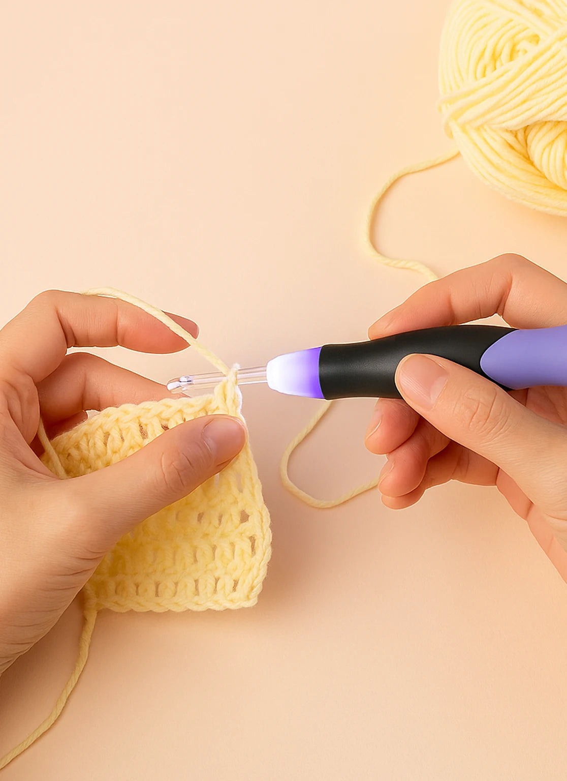 Close-up of hands crocheting yarn with an LED glowing crochet hook, highlighting the ergonomic handle for low-light crafting.